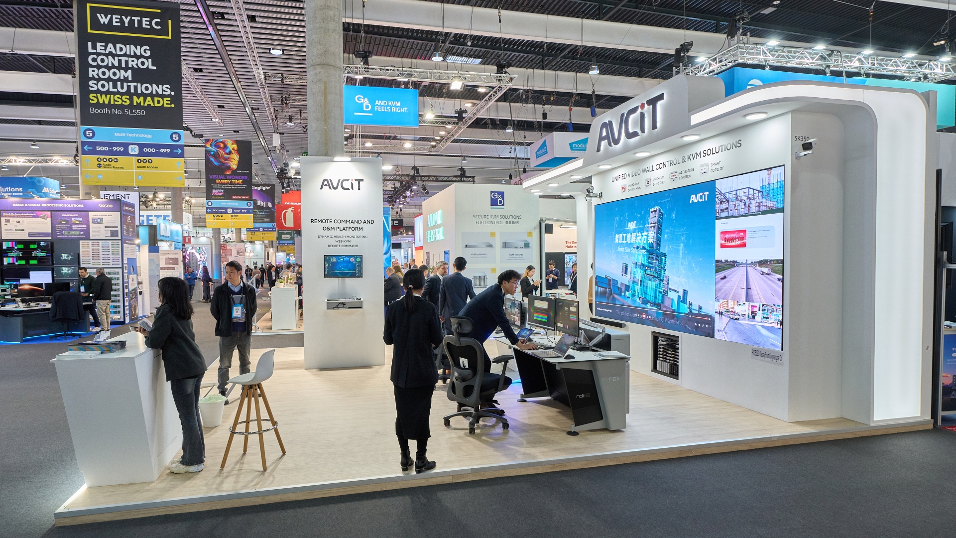Stand de AVCIT en feria de tecnología con pantallas y equipos para control de video.