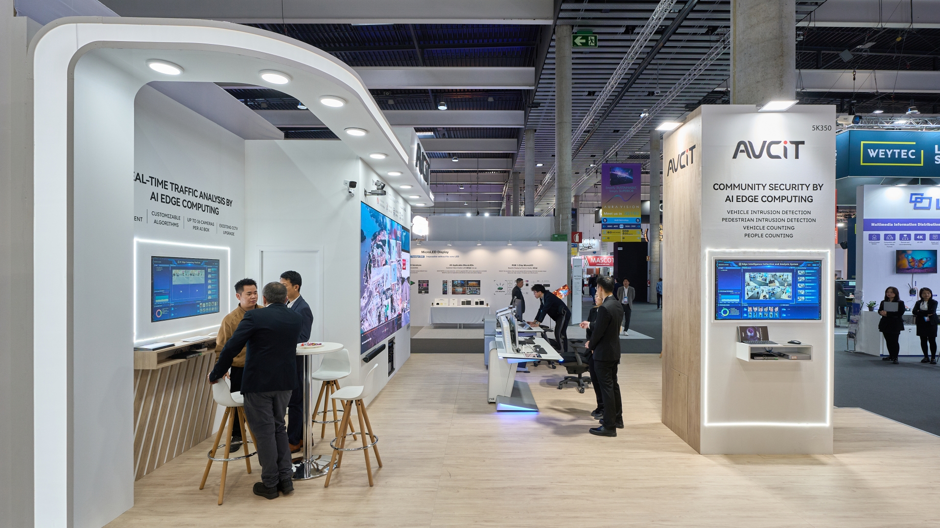 Pabellón de exhibición de soluciones tecnológicas con pantallas y seguridad avanzada.